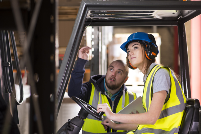 En man instruerar en kvinna i en truck