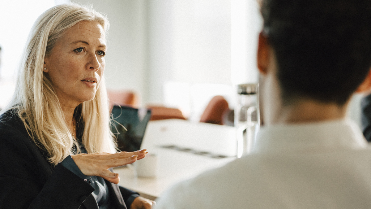 Kvinna och man i samtal i mötesrum