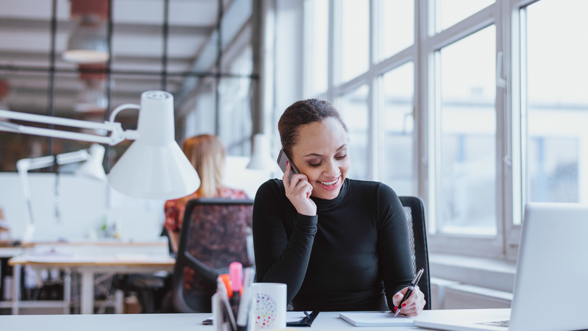 Glad kvinna i telefon.