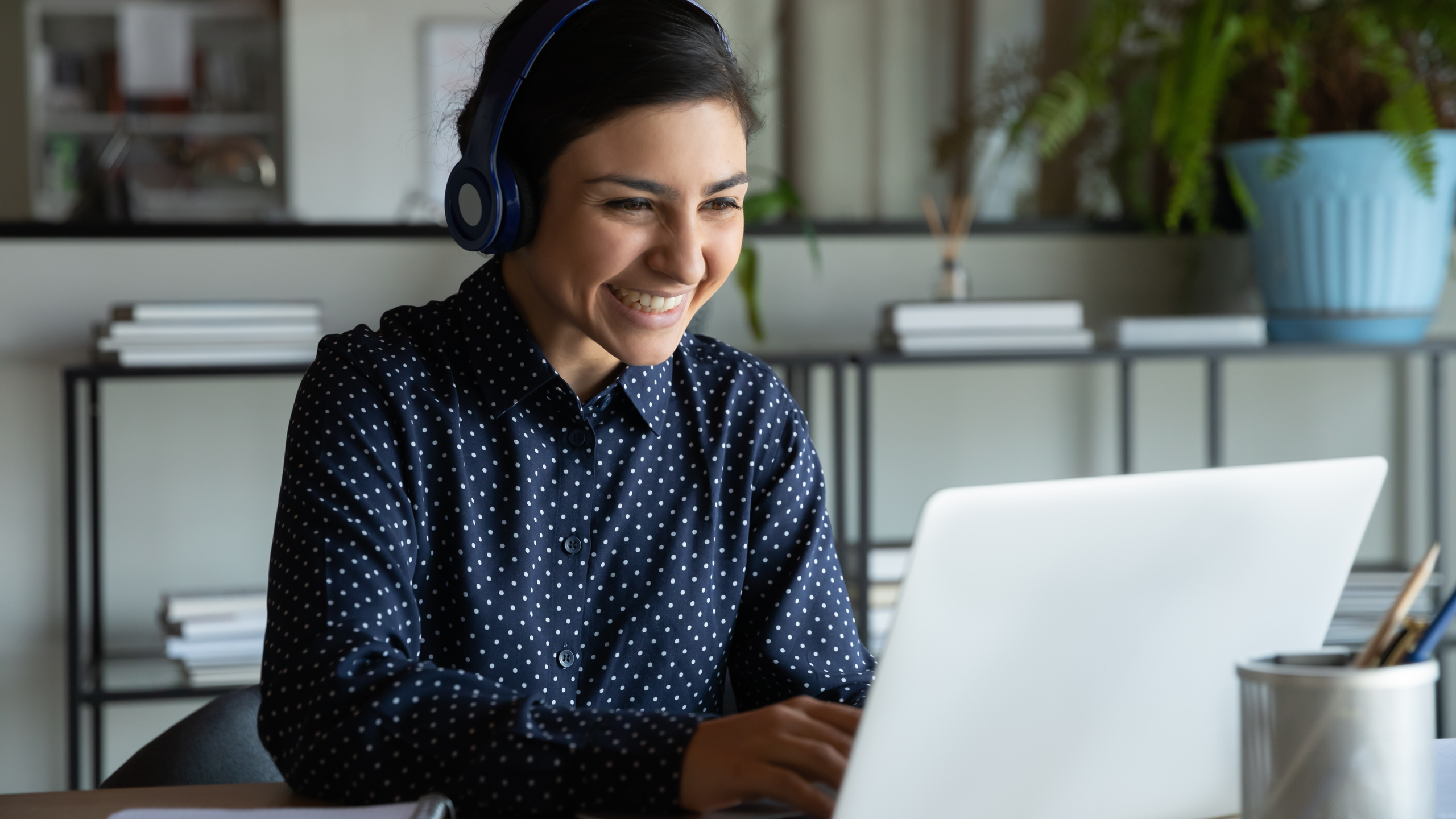 Glad kvinna i möte via sin dator.