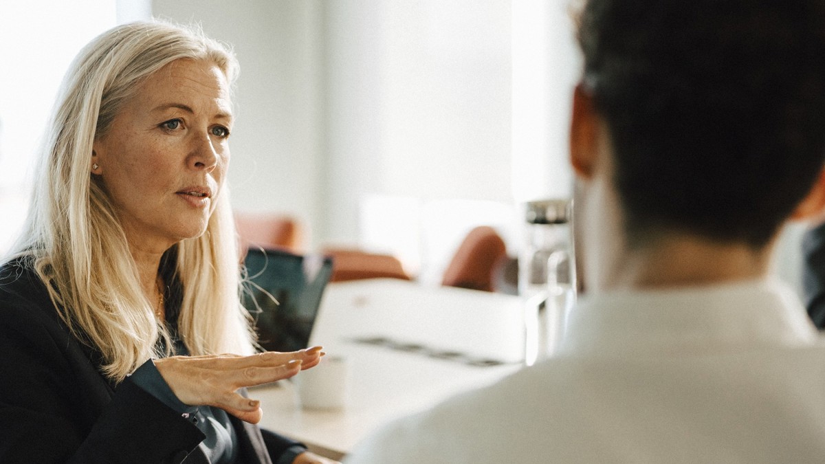 Samtal mellan kvinna och man i ett mötesrum.