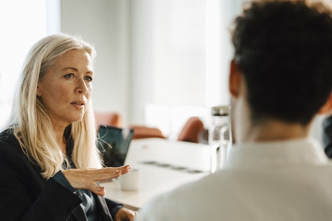 Samtal mellan kvinna och man i ett mötesrum.