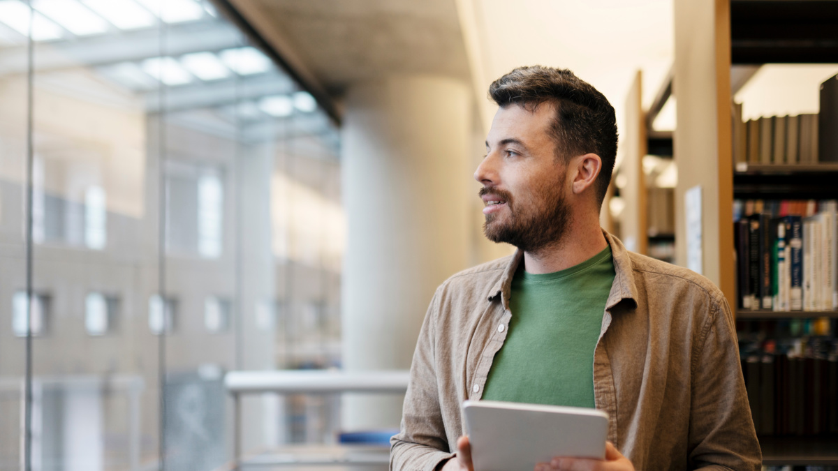 Ung man tittar ut genom fönstret.