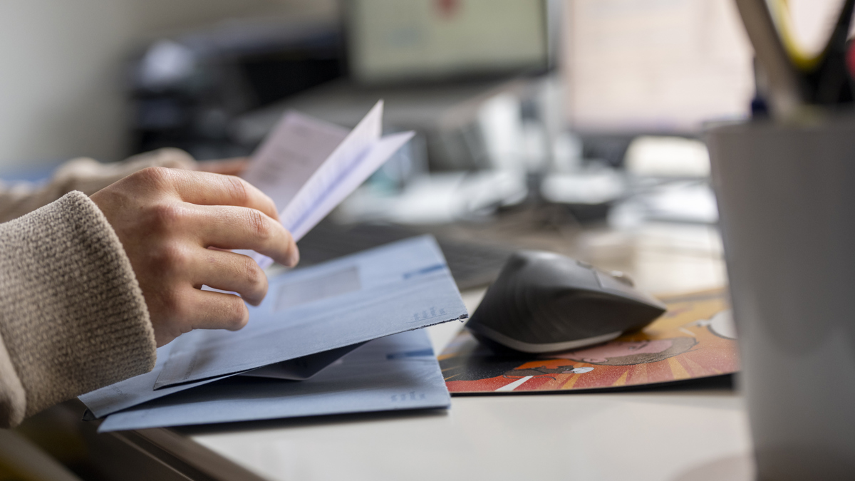 Händer öppnar kuvert.