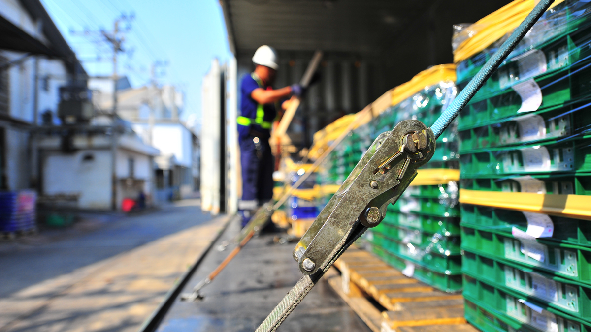 En man säkrar last.