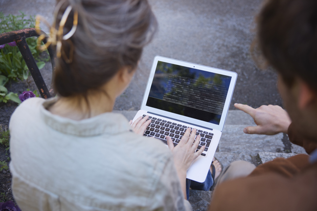 Två personer tittar på en datorskärm.