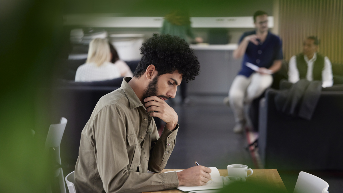 Ung man pluggar på kafé