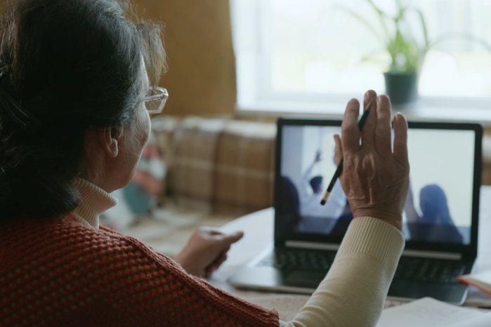 Video thumbnail, a woman is in a digital meeting waving at her computer screen