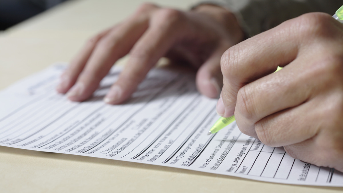 En person fyller i en blankett
